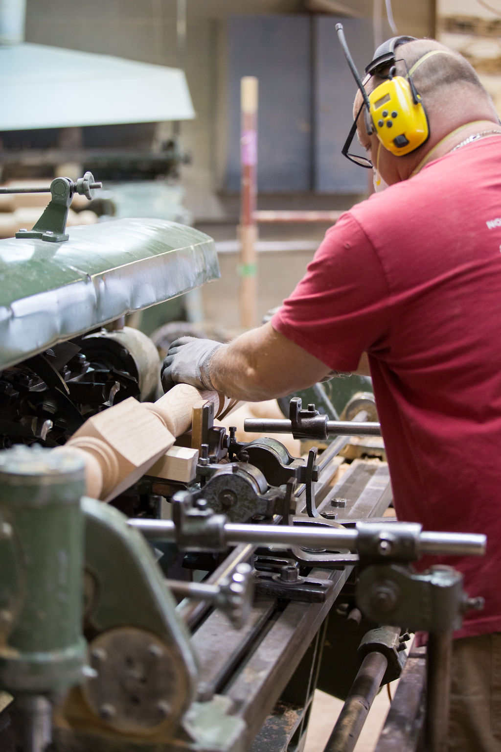 Hands guiding a spindle on a lathe